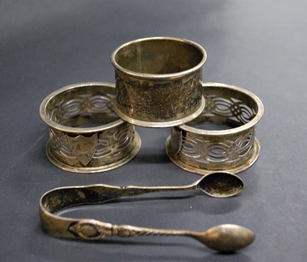 Three hallmarked-silver serviette rings and a pair of hallmarked-silver sugar-tongs Combined Weight