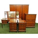 A bedroom suite of furniture by Stag, comprising a large triple wardrobe, a pair of bedside chests,