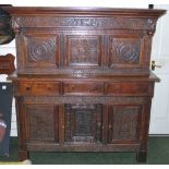 A large Jacobean-form court cupboard in oak, with carved panels and cupboard doors,