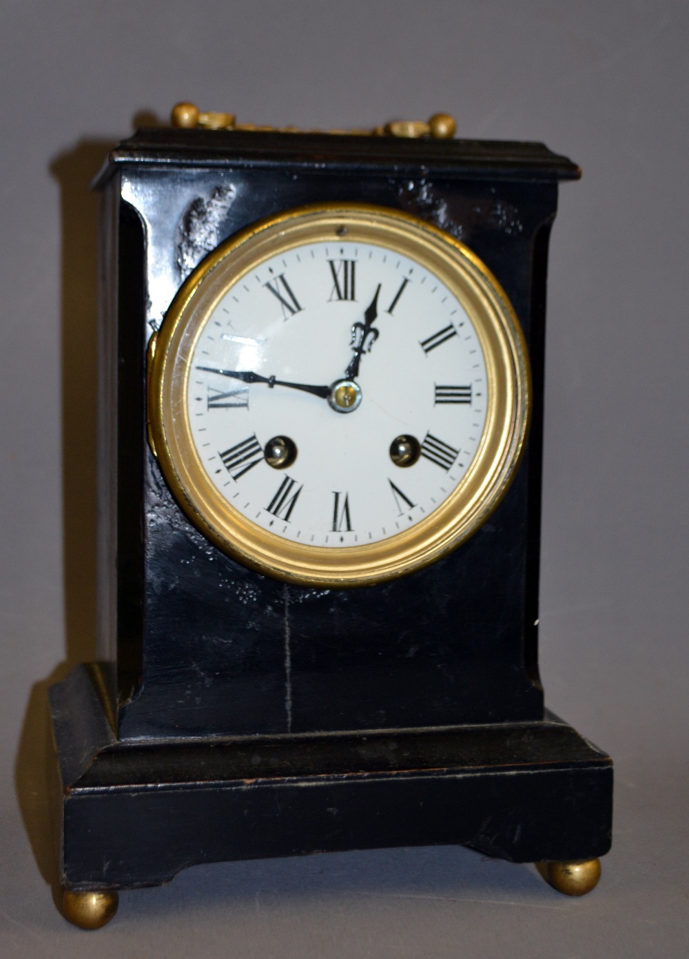 An ebonised French bracket clock having a circular enamelled dial with Roman chapters.