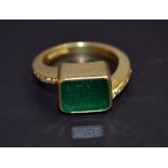 An 18ct yellow gold ladies dress ring with a large emerald and diamond shoulders. Marked .