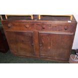An oak sideboard of two drawers above two cupboard doors.