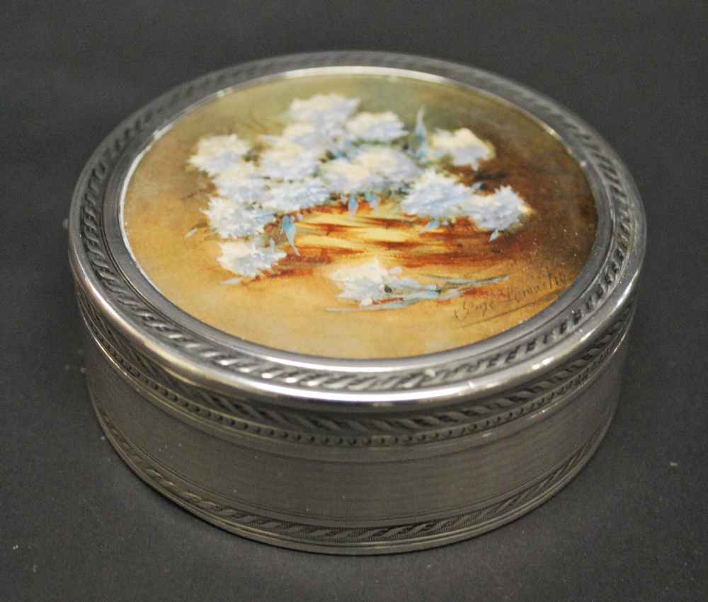 A circular French silver box, London import, 1912 with a signed miniature of flowers under glass,