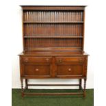 An oak panelled dresser with plate rack on barley twist supports,