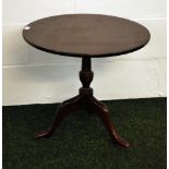 A circular mahogany reproduction tri-pod lamp table.