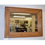 A large, pine framed wall mirror.