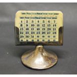 A hallmarked-silver weighted desk calendar with printed ivorine inserts