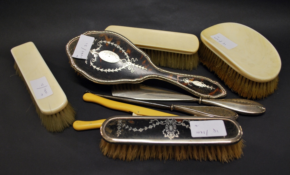 Two silver tortoiseshell backed brushes and a silver handled shoe horn and a silver handled button