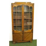 An oak Art Deco two door glazed bookcase with three adjustable shelves and a two door cupboard base.