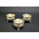 A set of three matching silver open salts with glass liners.