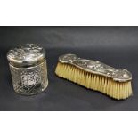 An Art Nouveau silver backed dressing brush along with a silver topped cut glass jar.