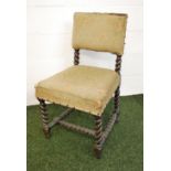 An antique oak dining chair having barley twist supports.