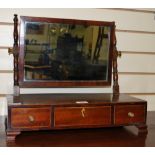 A small dressing mirror in mahogany with three short drawers raised on bracket feet.