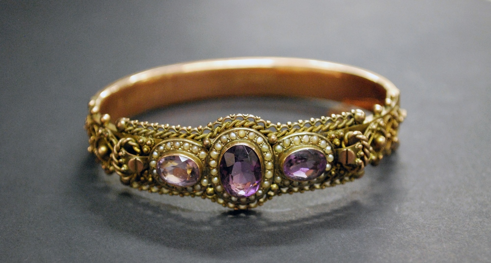 A Victorian 9ct gold snap-bangle, set with a trio of amethyst-type stones,