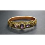 A Victorian 9ct gold snap-bangle, set with a trio of amethyst-type stones,