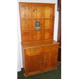 A contemporary pine dresser with a plate