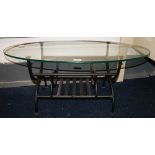 An oval glass coffee table on a wrought