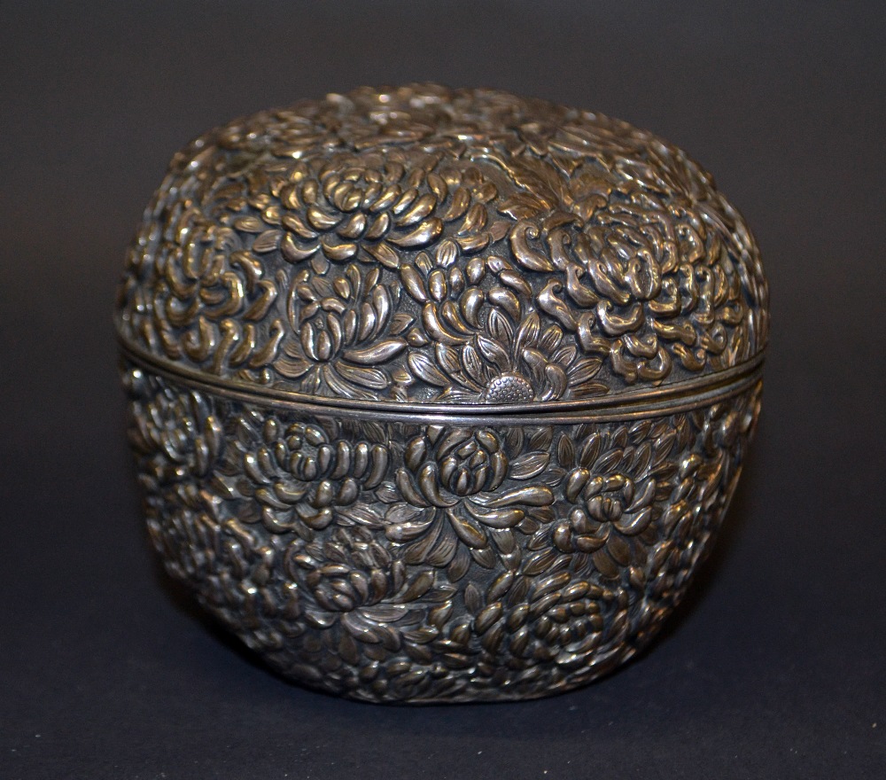 A Japanese silver circular pot with cover, relief decorated with chrysanthemums,