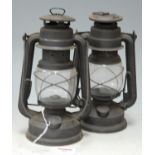A West German oil fired hand lantern together with one other similar (2)