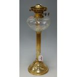 An early 20th century brass pedestal oil lamp with clear glass reservoir