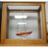 A small scale model of a 7 ton Bermudan sloop in associated display case