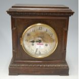 An continental oak cased mantel clock having silvered dial with Arabic numerals with eight day