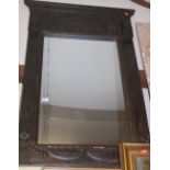An African carved and ebonised framed wall mirror