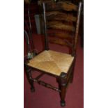 A set of four early 20th century elm and beech rush seat ladderback kitchen chairs