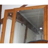 A pine framed and bevelled wall mirror;