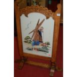 An oak framed fire screen with inset woolwork panel;