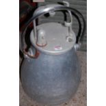 A galvanised metal swing handled milk container and cover