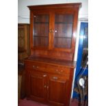 A contemporary cherrywood bookcase cupboard having twin door glazed upper section