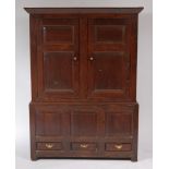 An 18th century joined oak housekeeper's cupboard, the upper section having twin panelled doors,