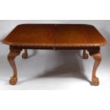 An extremely large early 20th century walnut round cornered extending dining table,