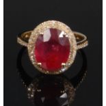 A contemporary 14ct yellow gold ruby and diamond dress ring, the oval cut ruby weighing 5.