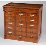 A circa 1900 oak office filing chest, arranged as fifteen short drawers, having panelled sides,