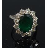 A ladies 18ct white gold emerald and diamond cluster ring,