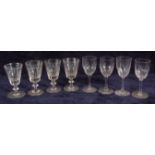 A set of twenty-six Victorian pedestal wine glasses, each with thumb-cut conical bowls,