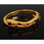 A Chinese 22ct yellow gold ruby and sapphire set serpent-head bangle, having hinged action,