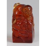 A Japanese carved amber seal, of square section depicting a robed figure with ducks, h.6.
