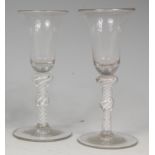 A pair of 18th century pedestal wine glasses,
