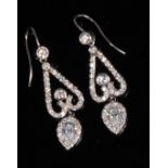 A pair of contemporary white metal diamond set ear pendants,