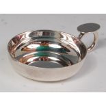 A contemporary silver wine taster, having a thumb-rest ringed handle, of plain circular form,
