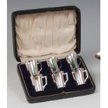 A cased set of six Art Nouveau silver spirit measures, each in the form of a tyg,