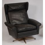 A 1960s Danish chrome framed and black leather upholstered swivel wing armchair,