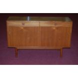 A 1960s teak sideboard by Vanson, having two drawers over twin sliding doors, on turned supports, h.