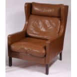 A Borge Morgensen 1960s Danish tan leather upholstered wing armchair, raised on square cut supports,