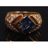 A modern 18ct gold, sapphire and diamond ring, lozenge set with nine square cut small sapphires,