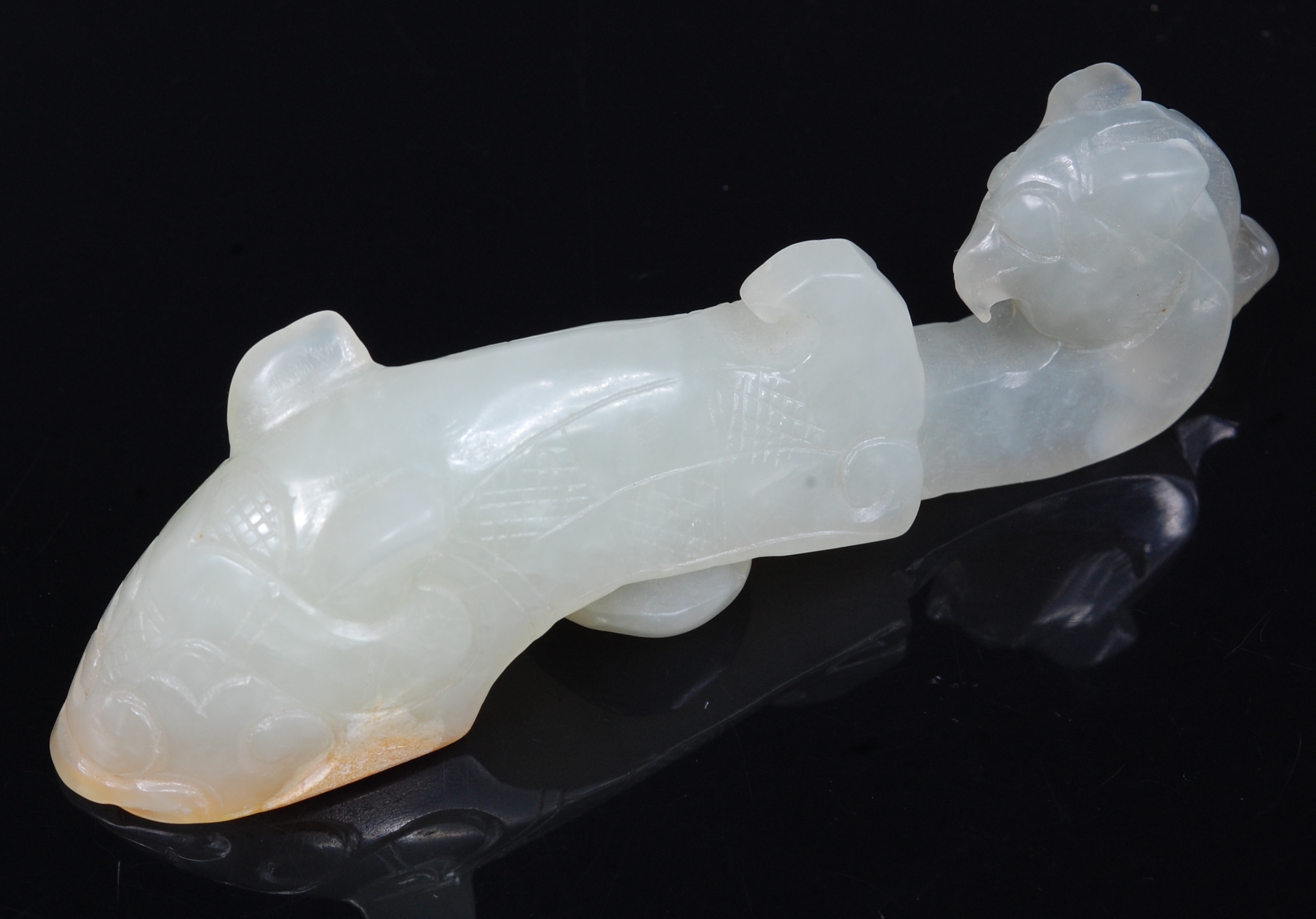 An early 20th century Chinese carved and polished celadon jade belt hook,