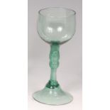 An 18th century continental green tinted pedestal wine glass,